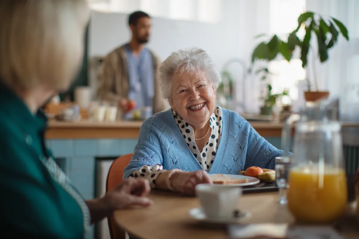 Senior woman smiling and enjoying breakfast